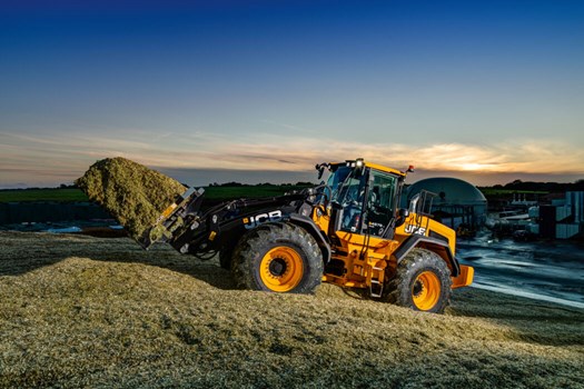 The 457S JCB Wheel Loader operating with a grass fork attachment in an Agricultural setting