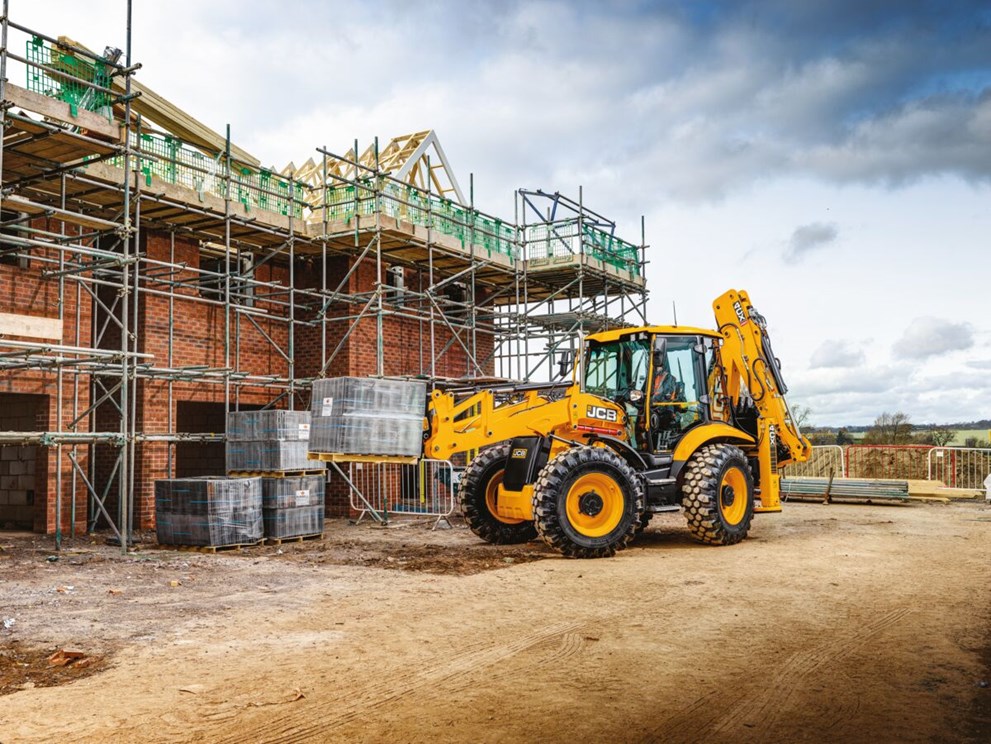 4CX Backhoe loader on a house building site lifting materials on forks