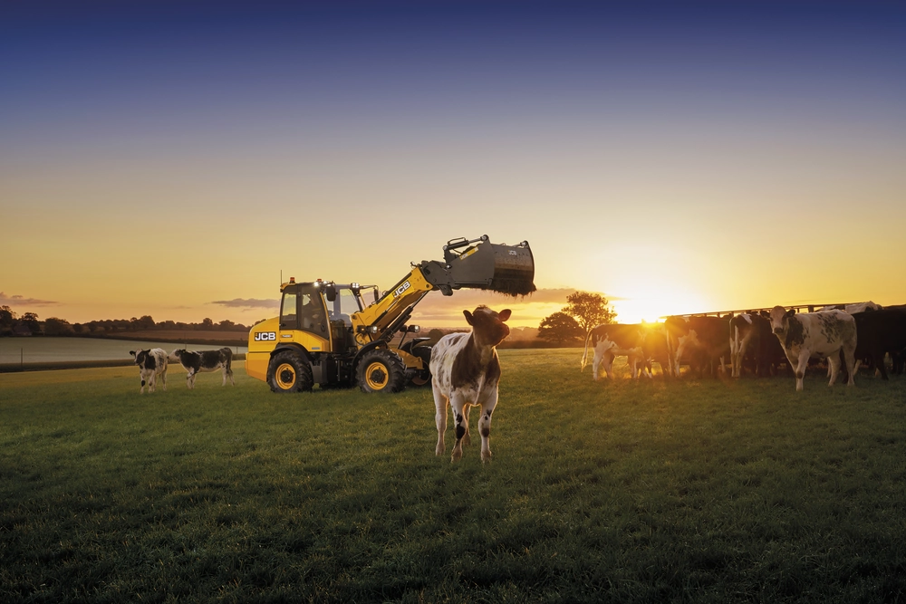 TM280S feeding cows at sunrise in a field