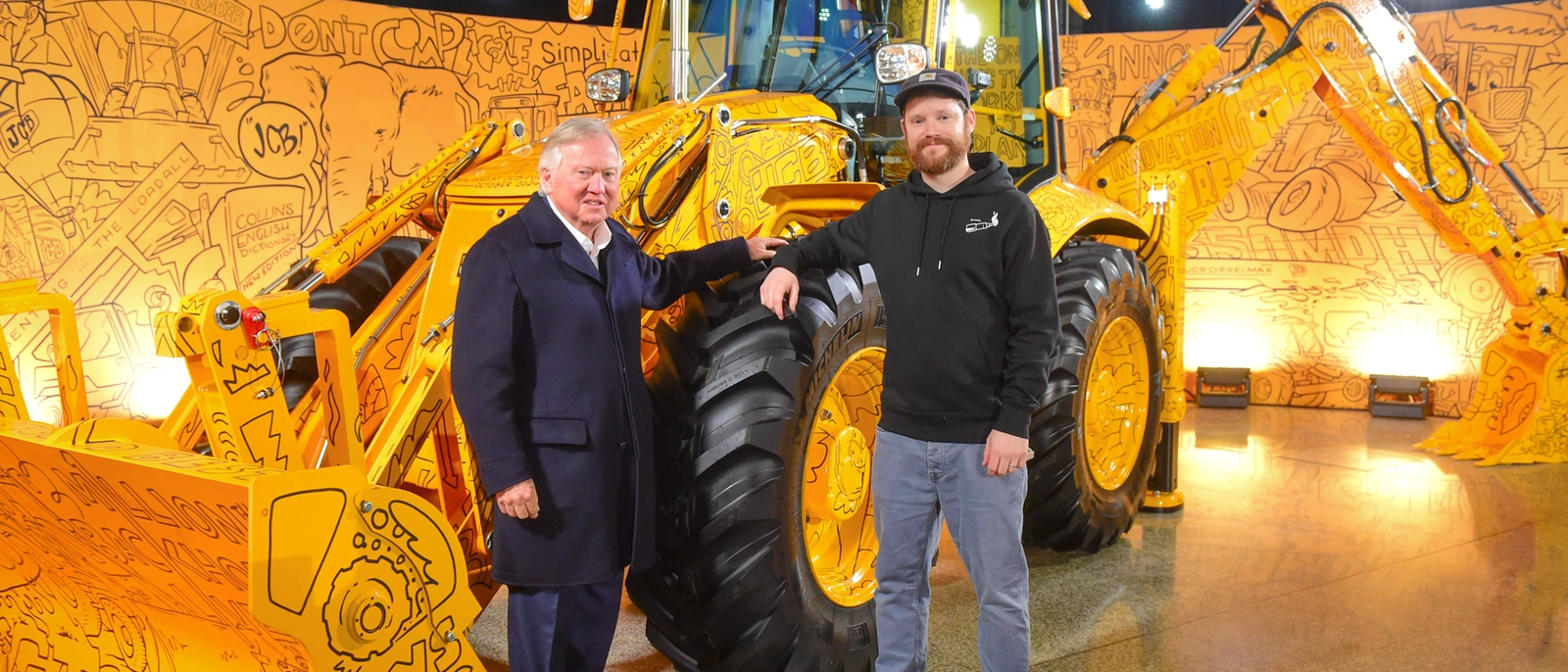 Lord Bamford with artist Dave Smith 'Hatch' and 1,000,000 Backhoe