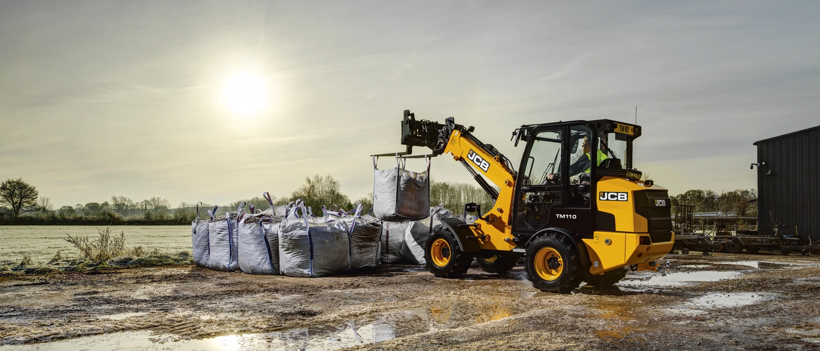 TM110 lifting bags of bark at a builder's merchant