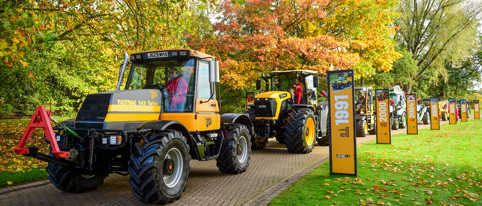 JCB Fastracs line up for the cavalcade next to the Fastrac board in JCB's 80th walkway